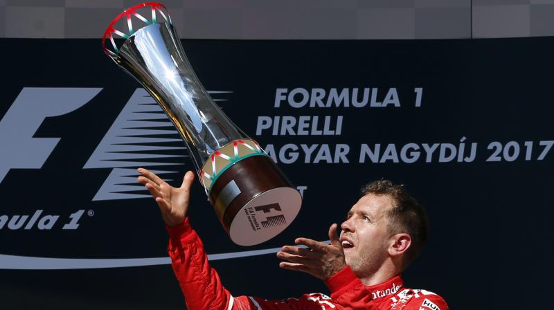 Ferrari driver Sebastian Vettel of Germany celebrates with his trophy after winning the Hungarian Formula One Grand Prix. (Photo: AP)