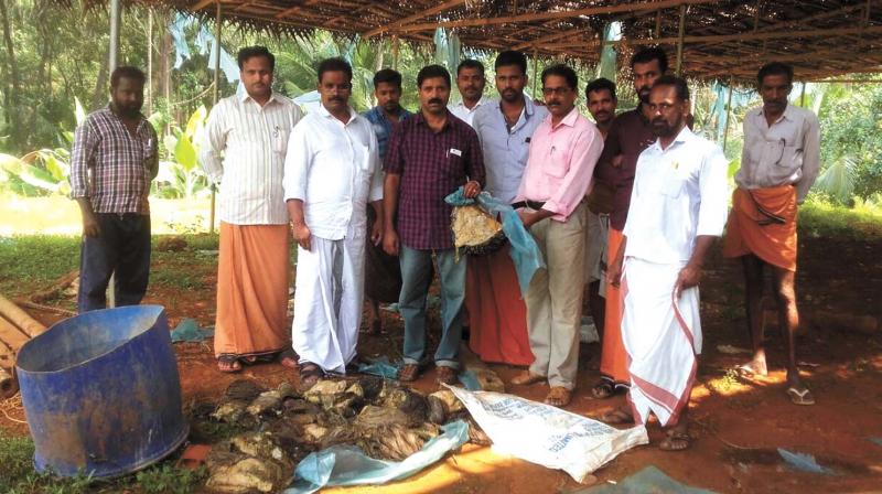 Residents with the meat recovered from two migrant labourers near Iritty on Friday.