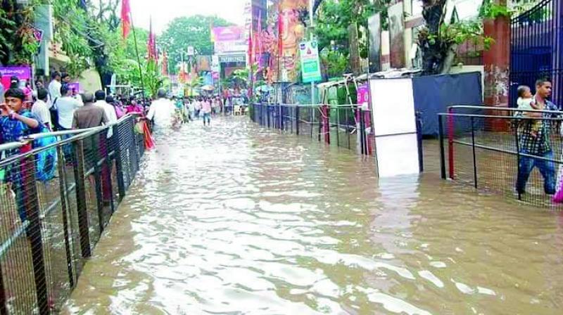 Devotees face inconvenience due to flooding at the Khairatabad Ganesh pandal due to the downpour on Monday evening.