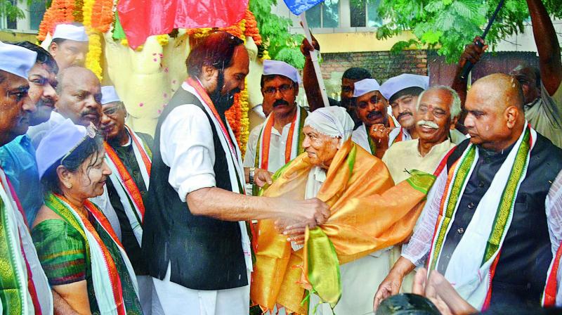 TPCC president N. Uttam Kumar Reddy and BJP MP from Hyderabad Bandaru Dattatreya honour a freedom fighter on the occasion of Telangana Liberation Day at Koti in Hyderabad on Monday.  	(Photo: S Surender Reddy)
