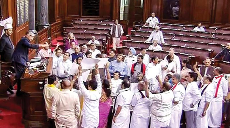 Opposition members, including Tamil Nadu MPs belonging to AIADMK and DMK, protest in the well of the Rajya Sabha in New Delhi on Tuesday. 	 PTI