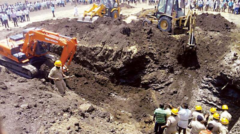 Rescue workers at the spot where two people fell into a borewell and died at Savadi village of Ron taluk in Gadag district, on Wednesday. (Photo: DC)