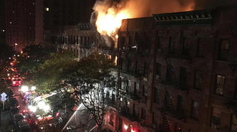 The flames quickly spread throughout the building and, at one point, were shooting out the roof, sending burning embers onto nearby buildings. (Photo: AP)