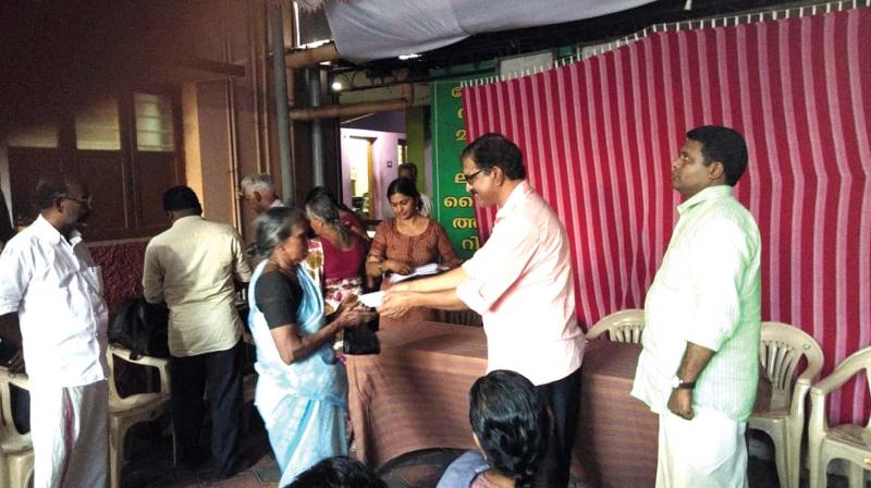 President of Gopalji Foundation D. Chandrasenan hands over financial assistance to a weaver at Chendamangalam on Friday.
