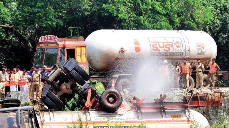 Fire and rescue personnel spray water on the gas tanker of Indian Oil Corporation, which overturned on the NH at Panambra, in Malappuram district, on Friday morning.