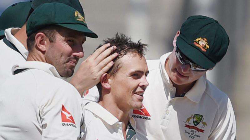 Steve OKeefe (C) surrounded by his teammates after picking up a wicket against India in Pune. (Photo: PTI)
