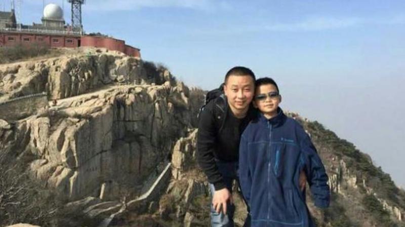 Cao Yinpeng, 8, with his father. (Photo: Weibo)