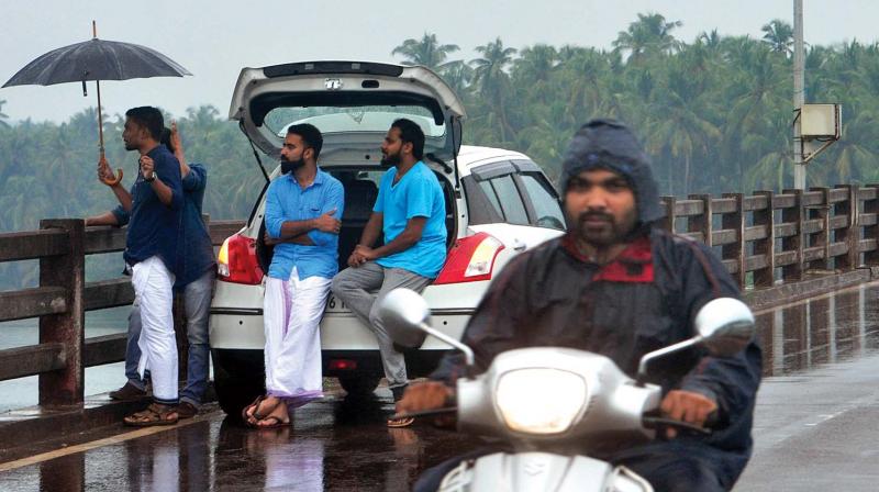 Youth enjoy showers ahead of monsoon at a bridge near Thiruvangoor in Kozhikode on Friday. (Photo: Venugopal)