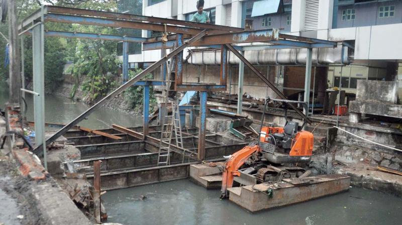 Workers of DMRC remove the pettiyum parayum, the traditional dewatering tool erected at Mullassery Canal as part of pre-monsoon cleaning works in Kochi on Friday.  (Photo: SUNOJ NINAN MATHEW)