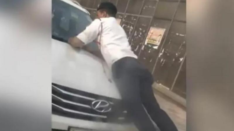 The video shared on social media starts where traffic cop is seen clinging to the hood of the car with his e-challan machine. (Photo: Screengrab)