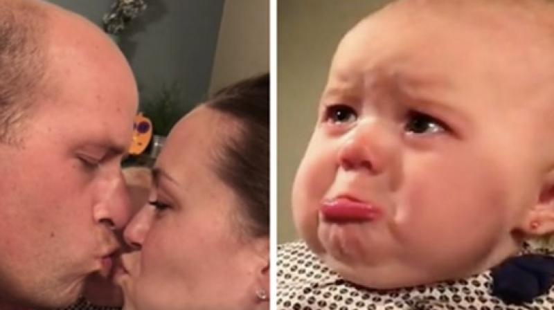Little Ella has become the darling of the internet after she was caught on camera crying every time her parents kissed each other. (Credit: YouTube)