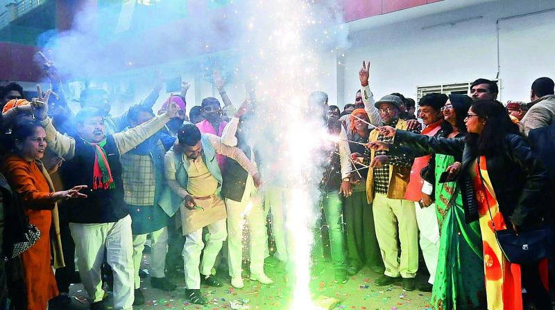 BJP workers celebrate partys victory in Gujarat and Himachal Pradesh Assembly elections, in Lucknow on Monday. 	(Photo: PTI)