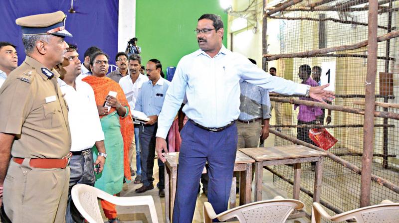 DEO D. Karthikeyan and city police commissioner A.K. Viswanathan review arrangements in counting centre at Queen Marys college, on Monday. (Photo: DC)