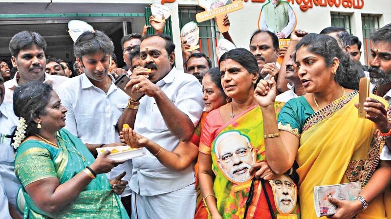 BJP state president Tamilisai Soundararajan distributes sweets to party functionaries following partys win in Gujarat and Himachal Pradesh Assembly elections, on Monday. (Photo: DC)