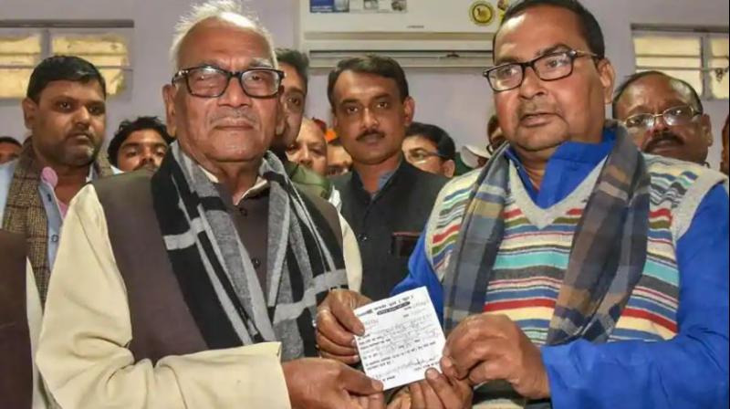 Bihar Janta Dal United president Vashishtha Narayan Singh presents the membership slip to former Rashtriya Lok Samata Party (RLSP) vice-president Bhagvan Singh Kushwaha as he joins JDU, in Patna on Friday. (Photo: PTI)