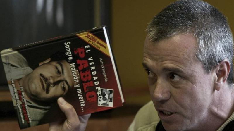 Jhon Jairo Velasquez, a former hit man for Pablo Escobar, gives his testimony while holding a book titled  The True Pablo, Blood, Treason, and Death,  during the trial against Alberto Santofimio Botero in Bogota, Colombia.(Photo: AP)