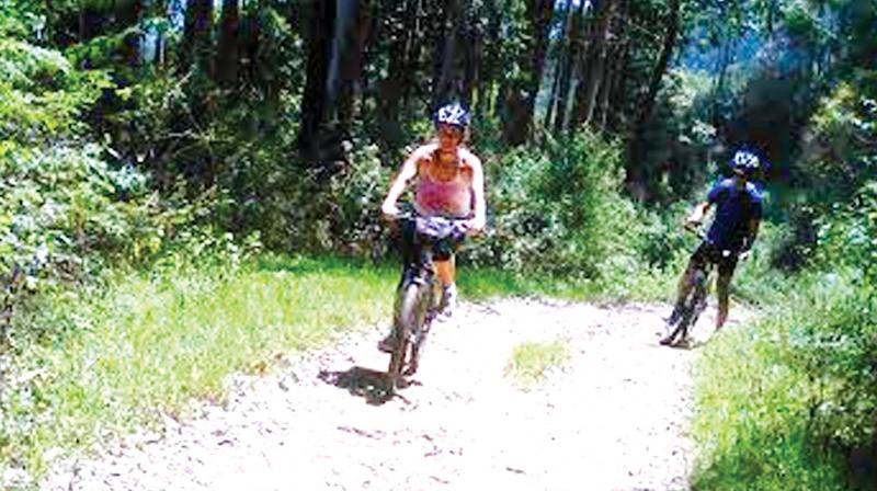 Tourists cycling on the mountain tracks of Munnar.