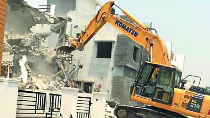 A bulldozer demolishes one of the 22 villas.
