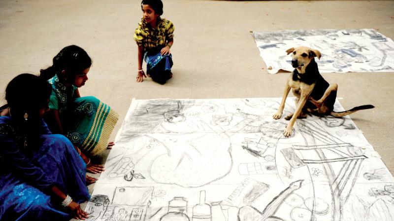 Children take a keen look at street art as a dog joins them R. Samuel