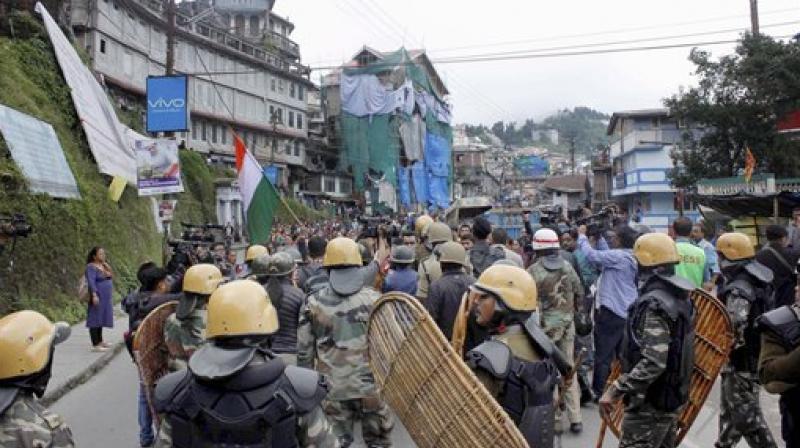 Security personnel stand guard during a protest by Gorkha Janmukti Morcha in Darjeeling Hills on Tuesday over West Bengal governments decision to teach Bengali in all schools. (Photo: PTI)