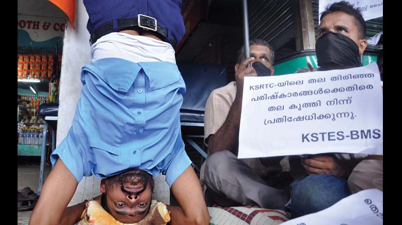 Biju, a KSRTC employee belonging to the BMS-affiliated KSTES union, stages a Sheershasana protest in Kochi on Saturday against the recent mass transfer in KSRTC. 	(Photo: SUNOJ NINAN MATHEW)