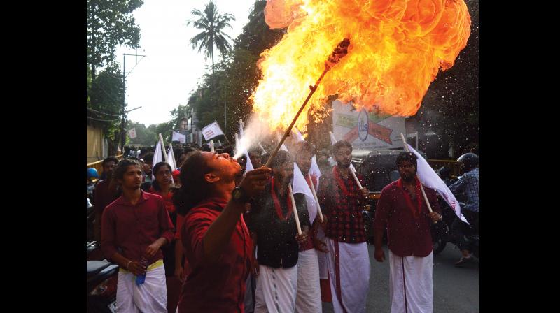 An SFI activist displays a fire stunt by spitting kerosene onto a torch to celebrate the victory in the union election in Malabar Christian College, Kozhikode on Thursday. (Photo: Priyanka p. Menon)
