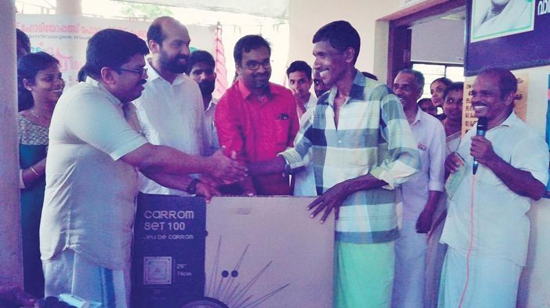 K.K. Ragesh, MP, distributes carrom boards to youngsters in the colonies.	 By arrangement