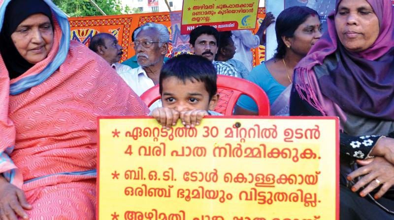 A child holds a placard demanding a six-lane highway in 30-metre width along the NH-17 from Edappally-Muthukunnam stretch during a meeting held at Edappally in Kochi on Thursday in protest against the decision of the district administration to acquire land for a 45-metre width. 	(Photo: SUNOJ NINAN MATHEW)