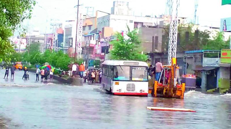 A crane is used to lift a bus that was stuck in the clogged waters. (Photo: DC)