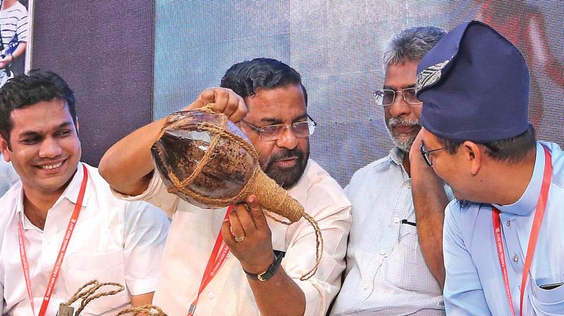 Tourism minister Kadakampally Surendran explains a handicraft product to a delegate at the Homestay and Rural Tourism Meet in Kochi on Friday. Hibi Eden, MLA, and John Fernandez, Anglo-Indian representative of state Assembly, are also seen. (Photo: SUNOJ NINAN MATHEW)
