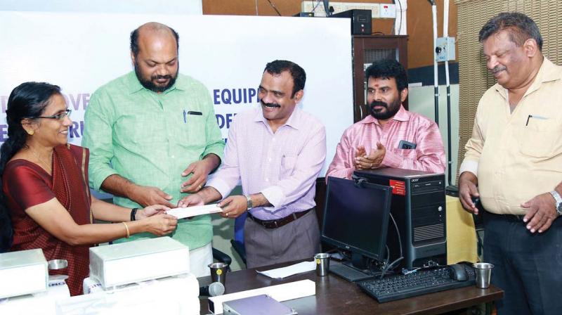 IMA Kochi branch president Dr. M. Narayanan hands over 40 lakh it collected for the free food distribution programme at Ernakulam General Hospital to hospital superintendent Dr A. Anitha in Kochi on Thursday. CPM district secretary P. Rajeev, Dr V. Madhu and Dr. Junaid Rahman look on.
