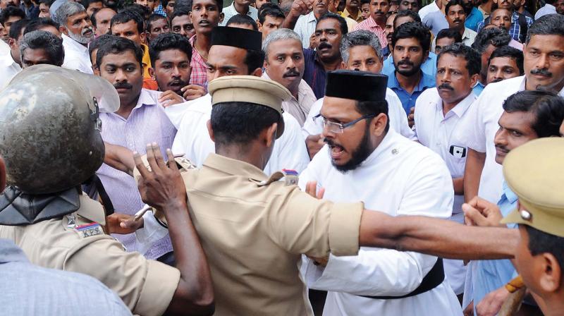 Priests argue with police officials during the dispute between the Jacobite and Orthodox factions on Varikkoli church premises near Kochi on Sunday. 	(Photo:  DC)