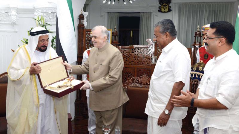 Governor P. Sathasivam presents a memento to Sharjah ruler Sheikh Sultan Bin Muhammad Al Qasimi who arrived at Raj Bhavan to meet the cabinet on Monday. Chief minister Pinarayi Vijayan and minister for local administration K.T. Jaleel look on. 	(Photo: DC)