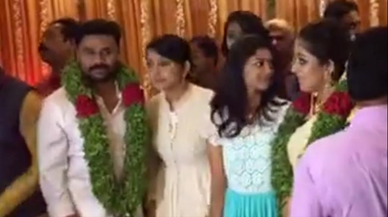 Newly married couple, Dileep and Kavya Madhavan pose with guests. (Screengrab: Mathrubhumi)