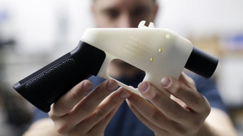 Cody Wilson, with Defense Distributed, holds a 3D-printed gun called the Liberator at his shop in Austin, Texas. (AP Photo/Eric Gay, file)