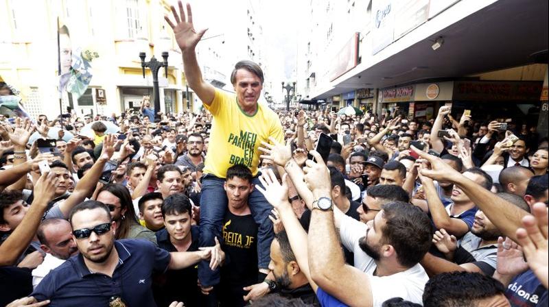 Presidential candidate Jair Bolsonaro is taken on the shoulders of a supporter moments before being stabbed during a campaign rally in Juiz de Fora, Brazil. (Photo: AP)