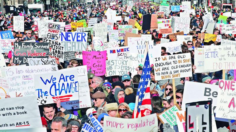 People hold signs on Pennsylvania Avenue at the â€œMarch for Our Livesâ€ rally, the biggest protest for gun control in a generation, on Saturday in Washington. 	 AP
