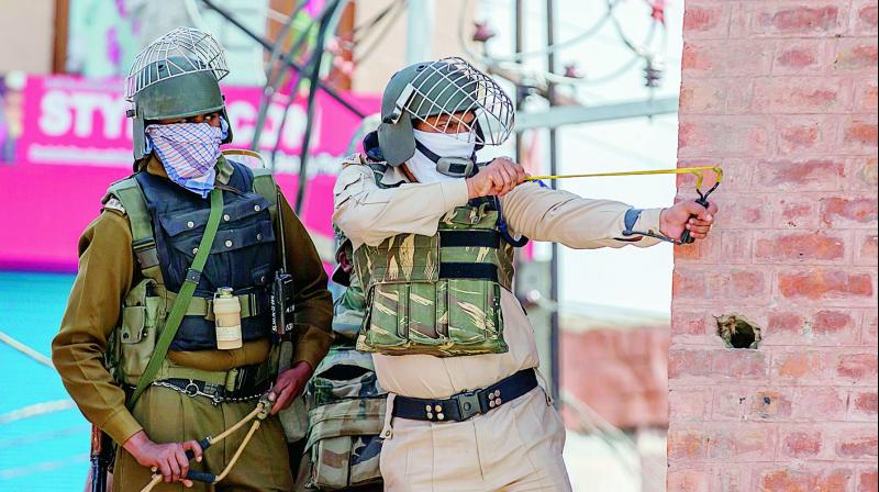 Soldiers use slings to shoot glass marbles at protesters in Srinagar on Friday. (Photo: AP)