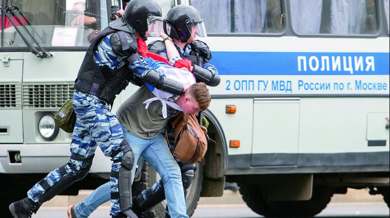Police arrest a protester covered with Russian flag in Moscow, Russia, on Monday. (Photo:  AFP)