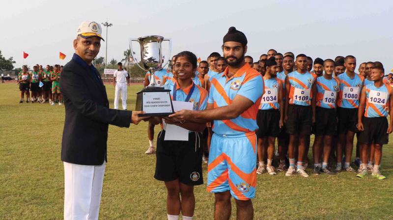 Rear Admiral Amit Vikram, principal of Indian Naval Academy, presents the Inter Squadron Novices Cross-Country Championship Trophy to Daredevil Squadronin Ezhimala on Sunday.