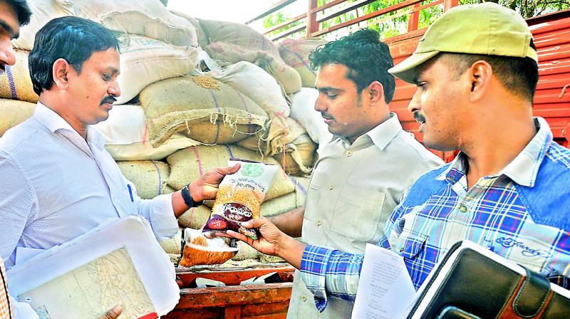 File picture of Civil Supplies officials check seized PDS grains.