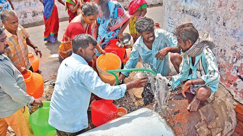 Residents collecting water in pots from the opening in water pipeline on Sunday, after it burst open. (Photo: DC)