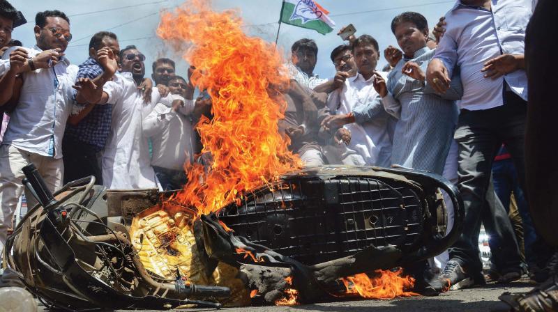 Congress workers set a bike on fire during Bharat Bandh in Jabalpur on Monday (Photo: PTI)