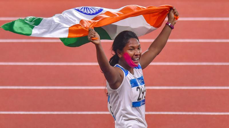 Competing with a plastered face owing to a teeth injury, described as a a case of infection, the battle-hardened Swapna topped the overall standings to garb her maiden Asiad gold. (Photo: PTI)