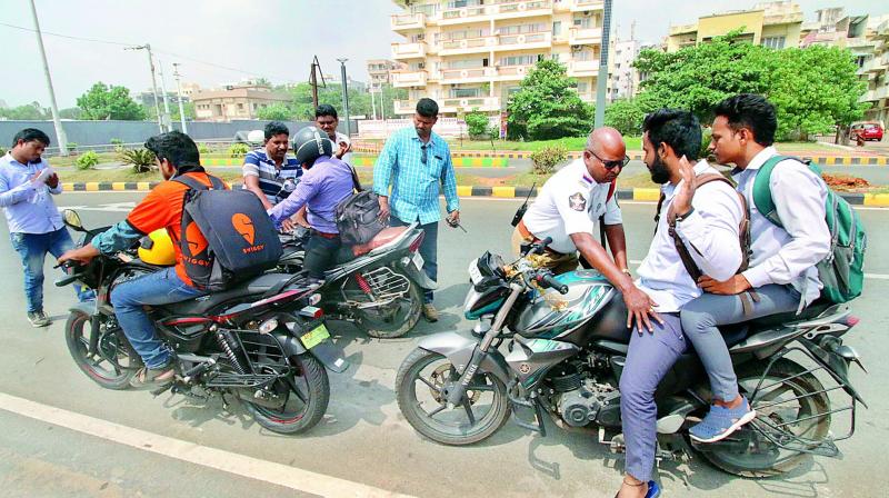 Police personnel inspect the vehicles in the city as many chain snatching cases were reported on Friday morning. (DECCAN CHRONICLE)