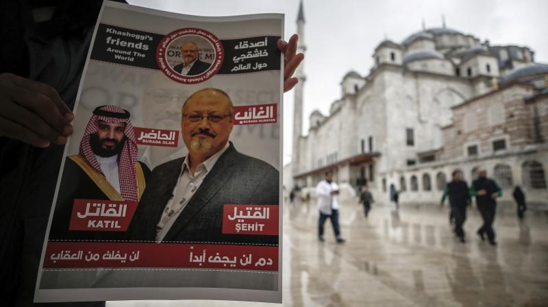 A man holds poster showing images of Saudi Crown Prince Muhammed bin Salman and of journalist writer Jamal Khashoggi, describing the prince as assassin and Khashoggi as martyr during funeral prayers in absentia for Khashoggi. (Photo: AP)