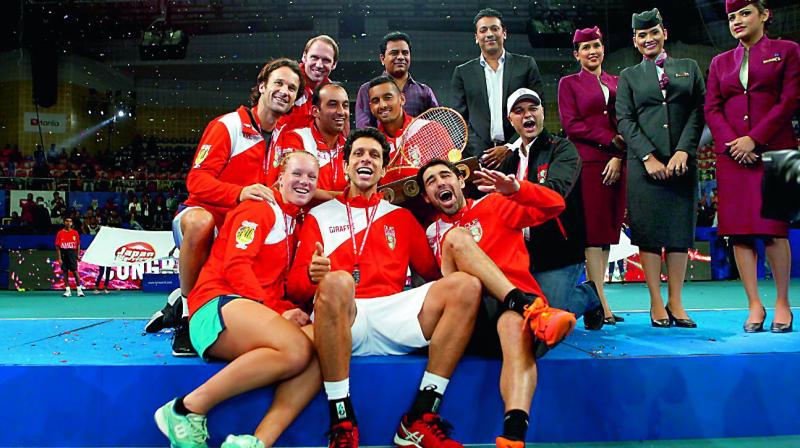 The Singapore Slammers are jubilant as they pose with the International Premier Tennis League trophy at the Gachibowli Indoor Stadium in Hyderabad on Sunday night.