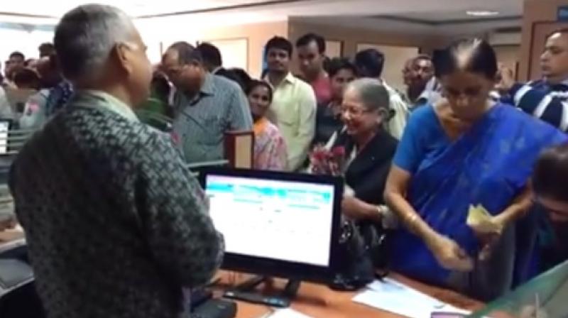 This video, which was uploaded by an SBI employee on November 20, shows the polite woman going to each bank employees desk and gifting them a rose. (Credit: Facebook)