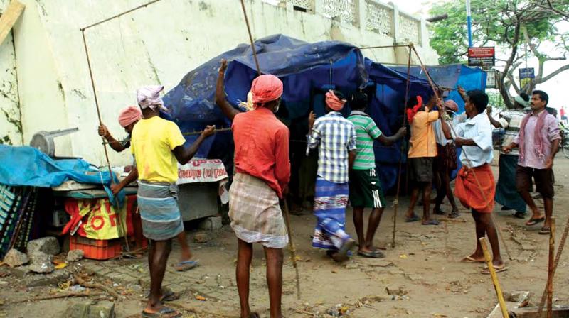 Workers demolishing wayside shops at Fort Kochi on Tuesday. (Photo: DC)