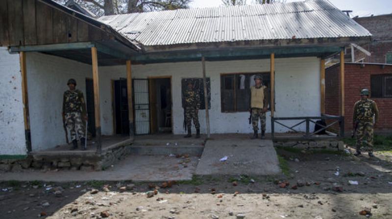 Paramilitary soldiers guard outside a polling station during a re-polling of a by-election for a vacant seat